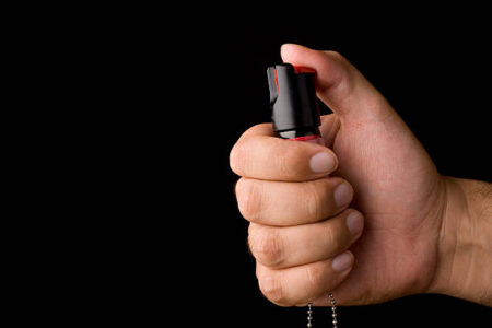 Gripped pepper spray ready to be fired. Shot against a black background. Visit some of these other fine collections.